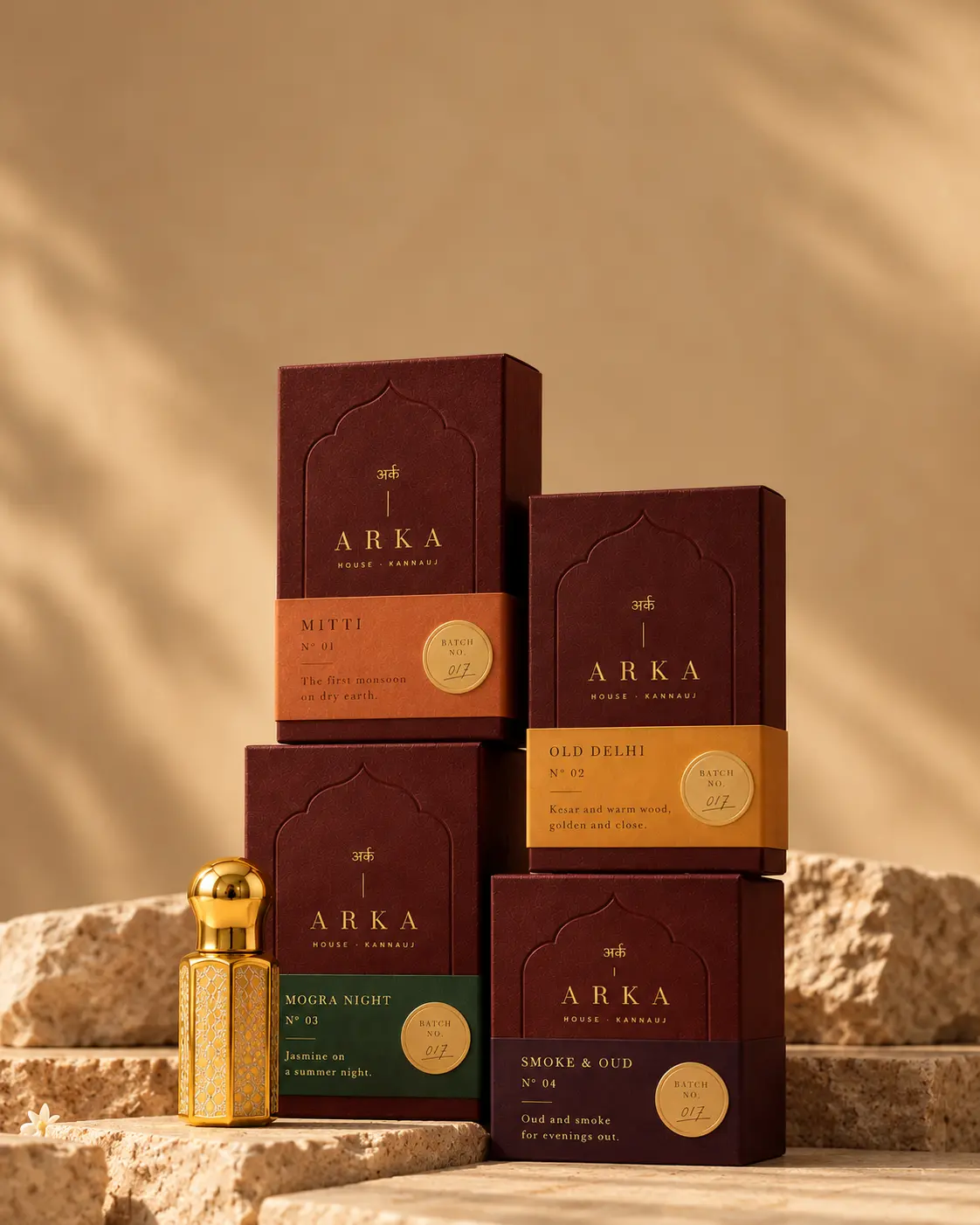 The Founding Four boxes stacked on warm stone with a gold flacon