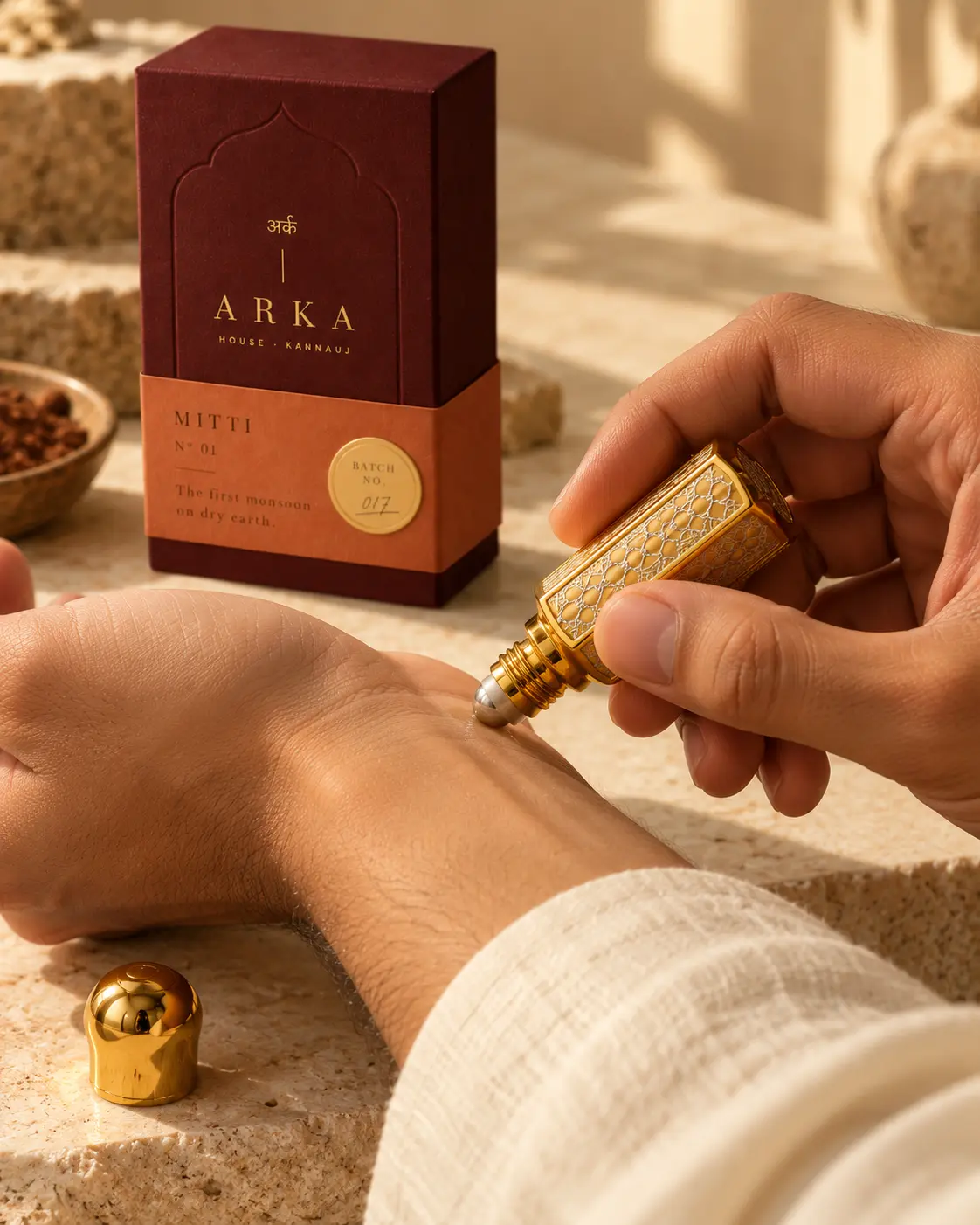 A gold flacon being rolled onto the wrist, with the Mitti box behind